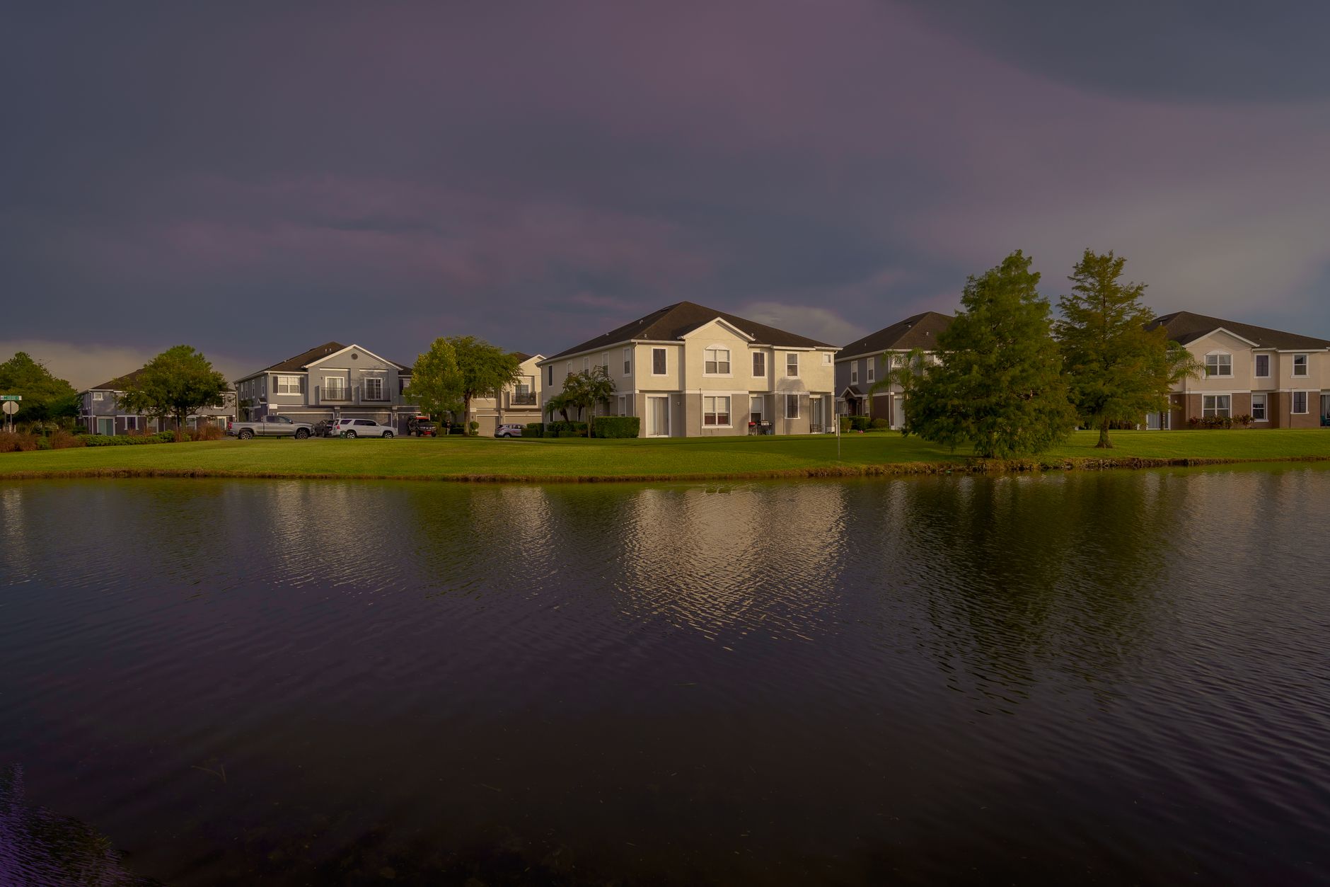Scenic view of lakefront homes reflecting on water under a dramatic sky in Orlando.