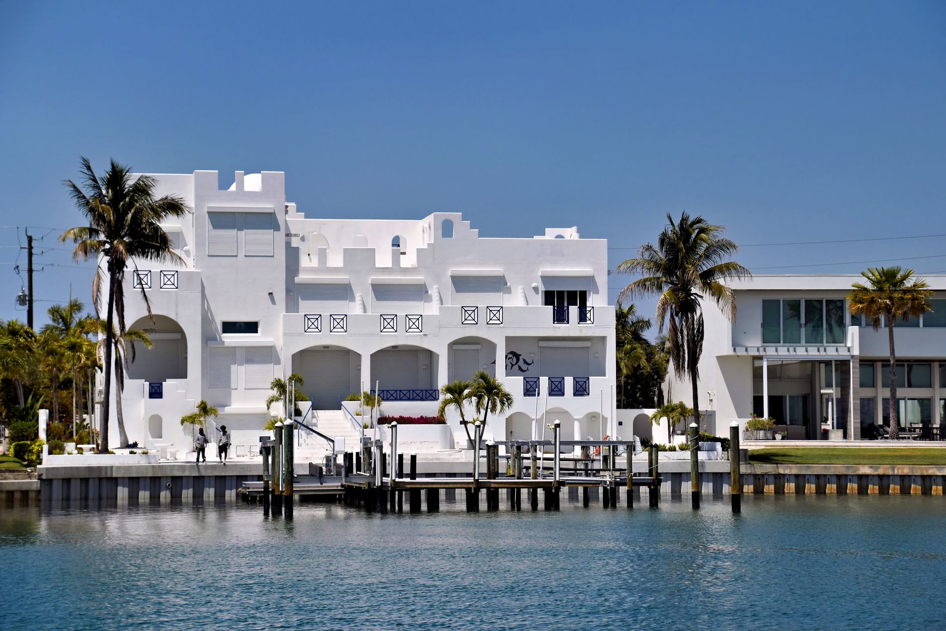 Stunning white modern waterfront house in sunny Sarasota, Florida alongside tranquil waterway.